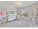 Bedroom featuring a crib, dresser, and a comfortable chair with natural light at 1094 Township Sq, Alpharetta, GA 30022