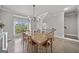 Bright dining room featuring a large wooden table, hardwood floors, and natural light from a large window at 1094 Township Sq, Alpharetta, GA 30022
