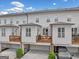 Rear exterior view of townhomes with decks, garages, and manicured landscaping at 1094 Township Sq, Alpharetta, GA 30022