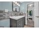 Charming bathroom featuring a sleek vanity, mosaic backsplash, and views into bedroom & closet at 136 Glynn Addy Dr, Stockbridge, GA 30281
