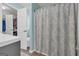 A well-lit bathroom offers a blend of functionality and style with a patterned shower curtain at 136 Glynn Addy Dr, Stockbridge, GA 30281