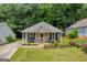 Charming tan home with a covered porch and well-maintained landscaping, nestled among lush trees at 136 Glynn Addy Dr, Stockbridge, GA 30281
