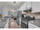 Updated kitchen featuring stainless steel appliances, white shaker cabinets, and easy access to the adjacent living space at 136 Glynn Addy Dr, Stockbridge, GA 30281