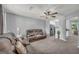 Spacious living room featuring plush carpet, a ceiling fan, and comfortable leather seating at 136 Glynn Addy Dr, Stockbridge, GA 30281