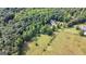 Aerial view of a property with open fields and mature trees surrounding the house at 1561 Aiken Chafin Ln, Mcdonough, GA 30252