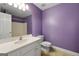 Cozy bathroom featuring white vanity, toilet, light purple walls, and a tiled floor at 1561 Aiken Chafin Ln, Mcdonough, GA 30252
