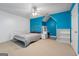 Stylish bedroom features vibrant blue accent wall, white furnishings, and modern ceiling fan at 1561 Aiken Chafin Ln, Mcdonough, GA 30252