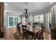 Elegant dining room showcasing wood table, stylish chandelier, and views of landscaped outdoors at 1561 Aiken Chafin Ln, Mcdonough, GA 30252