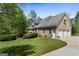 Brick home with three-car garage, lush lawn, and well-maintained landscaping in the backyard at 1561 Aiken Chafin Ln, Mcdonough, GA 30252