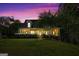 Inviting exterior view of a traditional home with a covered porch, complemented by a beautifully landscaped lawn at dusk at 1561 Aiken Chafin Ln, Mcdonough, GA 30252