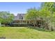 Inviting front exterior featuring a charming covered porch, a well-maintained lawn, and mature trees for added privacy at 1561 Aiken Chafin Ln, Mcdonough, GA 30252