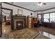 Stone fireplace in this well-appointed home office with desk and doorway to adjacent living room at 1561 Aiken Chafin Ln, Mcdonough, GA 30252