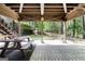 View of covered patio featuring picnic table with access to stairs and large green wooded backyard at 1561 Aiken Chafin Ln, Mcdonough, GA 30252