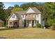 Charming two-story home featuring a combination of brick and siding, complemented by a well-manicured lawn and mature trees at 85 Bloomfield Way, Sharpsburg, GA 30277