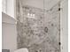 Modern bathroom shower with glass door and attractive stone-patterned tile walls at 85 Bloomfield Way, Sharpsburg, GA 30277