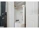Enclosed white tiled shower with a shower head and a small shelf, accessed through double doors at 508 Hastings Dr, Peachtree City, GA 30269