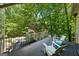 Spacious outdoor deck with black railing, two chairs, and surrounded by beautiful, lush trees at 508 Hastings Dr, Peachtree City, GA 30269