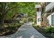 View of an elegant home's driveway leading to a covered connecting area next to a manicured lawn at 508 Hastings Dr, Peachtree City, GA 30269