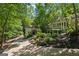 Beautiful home exterior with lush greenery, a winding driveway, and a charming screened porch at 508 Hastings Dr, Peachtree City, GA 30269