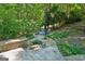 Inviting stone patio with an outdoor firepit and comfortable seating surrounded by lush greenery at 508 Hastings Dr, Peachtree City, GA 30269