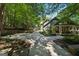 Home featuring lush landscaping, a covered connecting area, and a long driveway in a wooded setting at 508 Hastings Dr, Peachtree City, GA 30269