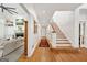 Bright hallway with hardwood floors, stairs, and a living room view with a fireplace at 508 Hastings Dr, Peachtree City, GA 30269
