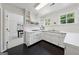 Bright kitchen featuring white cabinetry, modern appliances, black floors, and a sunlit view at 508 Hastings Dr, Peachtree City, GA 30269