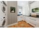 Well-lit laundry room features a utility sink, modern appliances, and plenty of storage with custom white cabinets at 508 Hastings Dr, Peachtree City, GA 30269