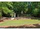 A quaint shed sits nestled among mature trees and lush greenery, complemented by a charming bridge at 508 Hastings Dr, Peachtree City, GA 30269