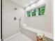 Bright and modern shower with floor-to-ceiling tile, a built-in bench, and large window at 508 Hastings Dr, Peachtree City, GA 30269