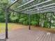 A deck in the backyard is covered with wooden planks under a black metal pergola at 506 Brewer Dr, Locust Grove, GA 30248