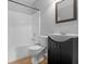 A bathroom with a tub/shower combo, a toilet and a black vanity with a sink and mirror at 506 Brewer Dr, Locust Grove, GA 30248