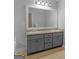 Bathroom featuring a double sink vanity with gray cabinets, a large mirror, and a bathtub at 506 Brewer Dr, Locust Grove, GA 30248