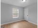A bright, neutral bedroom space featuring a window and light wood-look flooring at 506 Brewer Dr, Locust Grove, GA 30248