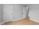 Neutral bedroom featuring light wood flooring and a convenient ensuite bathroom entrance at 506 Brewer Dr, Locust Grove, GA 30248