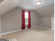 Bright bonus room with carpet and neutral paint and dormer window with red curtain at 506 Brewer Dr, Locust Grove, GA 30248