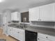 Kitchen featuring white cabinets, gray countertops, and a black dishwasher at 506 Brewer Dr, Locust Grove, GA 30248