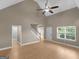 Open-concept living room with wood floors, a staircase, and a front entry door at 506 Brewer Dr, Locust Grove, GA 30248