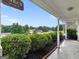 Covered porch with 'Sit & Relax' sign, brick trim, lush landscaping, and distant views at 506 Brewer Dr, Locust Grove, GA 30248