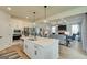 Open concept kitchen offers white cabinets, stainless appliances, and island with quartz countertops, seamlessly flowing into the living area at 43 Avian Way # 3B, Auburn, GA 30011