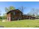 Expansive backyard featuring wood and brick exterior, a well-maintained lawn, and mature trees at 1919 101 S Hwy, Temple, GA 30179