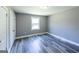 Bedroom featuring gray walls, hardwood floors, and a bright, sunny window at 1919 101 S Hwy, Temple, GA 30179