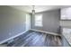 Dining area featuring gray walls, wood floors, white cabinets, and modern pendant lighting at 1919 101 S Hwy, Temple, GA 30179