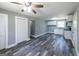 Bright living room with gray walls, wood-look floors, modern ceiling fan, and adjacent updated kitchen space at 1919 101 S Hwy, Temple, GA 30179
