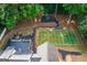 Aerial view of football field, playground, deck, and fire pit in wooded backyard at 870 Rutherford Dr, Dacula, GA 30019