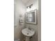 Charming half bathroom boasts pedestal sink, decorative mirror, and updated fixtures at 870 Rutherford Dr, Dacula, GA 30019