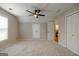 Bedroom has neutral carpet, ceiling fan, and closet with view into an en suite bathroom at 870 Rutherford Dr, Dacula, GA 30019