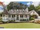 Charming home featuring a welcoming front porch, black shutters, and manicured landscaping at 870 Rutherford Dr, Dacula, GA 30019