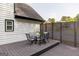Cozy outdoor patio with a glass top table and seating for six, enclosed with a modern privacy fence at 870 Rutherford Dr, Dacula, GA 30019