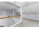 A carpeted bonus room/attic space with wood and white railing and ample sunlight at 11765 Fairway Overlook, Fayetteville, GA 30215